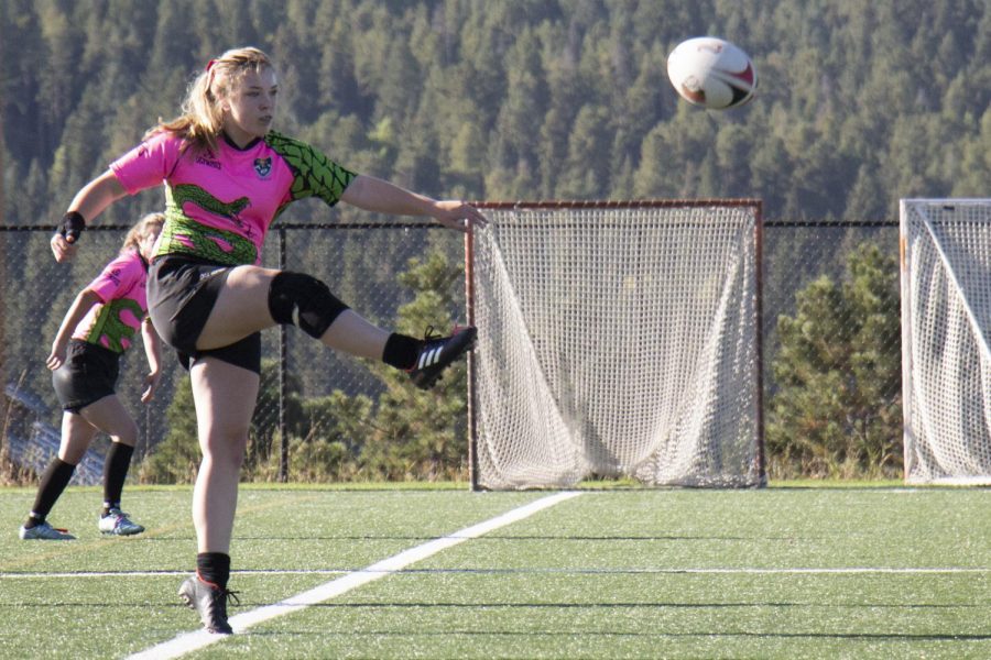 Ella Wilson, 11 dropkicks the ball during kick off. 